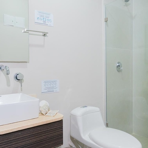 Baño moderno en Hotel Ribai Corporativa con lavabo y regadera.