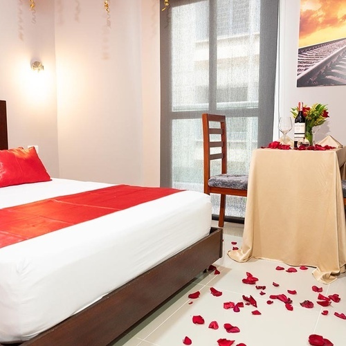 Habitación romántica en Hotel Ribai Corporativa con cama y mesa para cena.