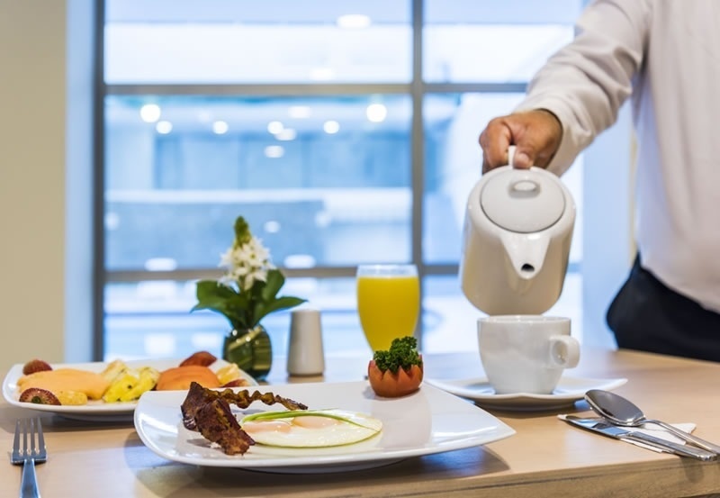 Desayuno completo en Hotel Ribai Corporativa: frutas, huevo, tocino y jugo.