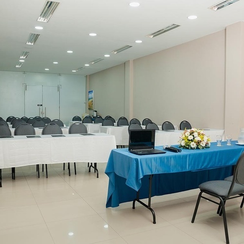 Sala de juntas en Hotel Ribai Corporativa con mesas, sillas y laptop lista.