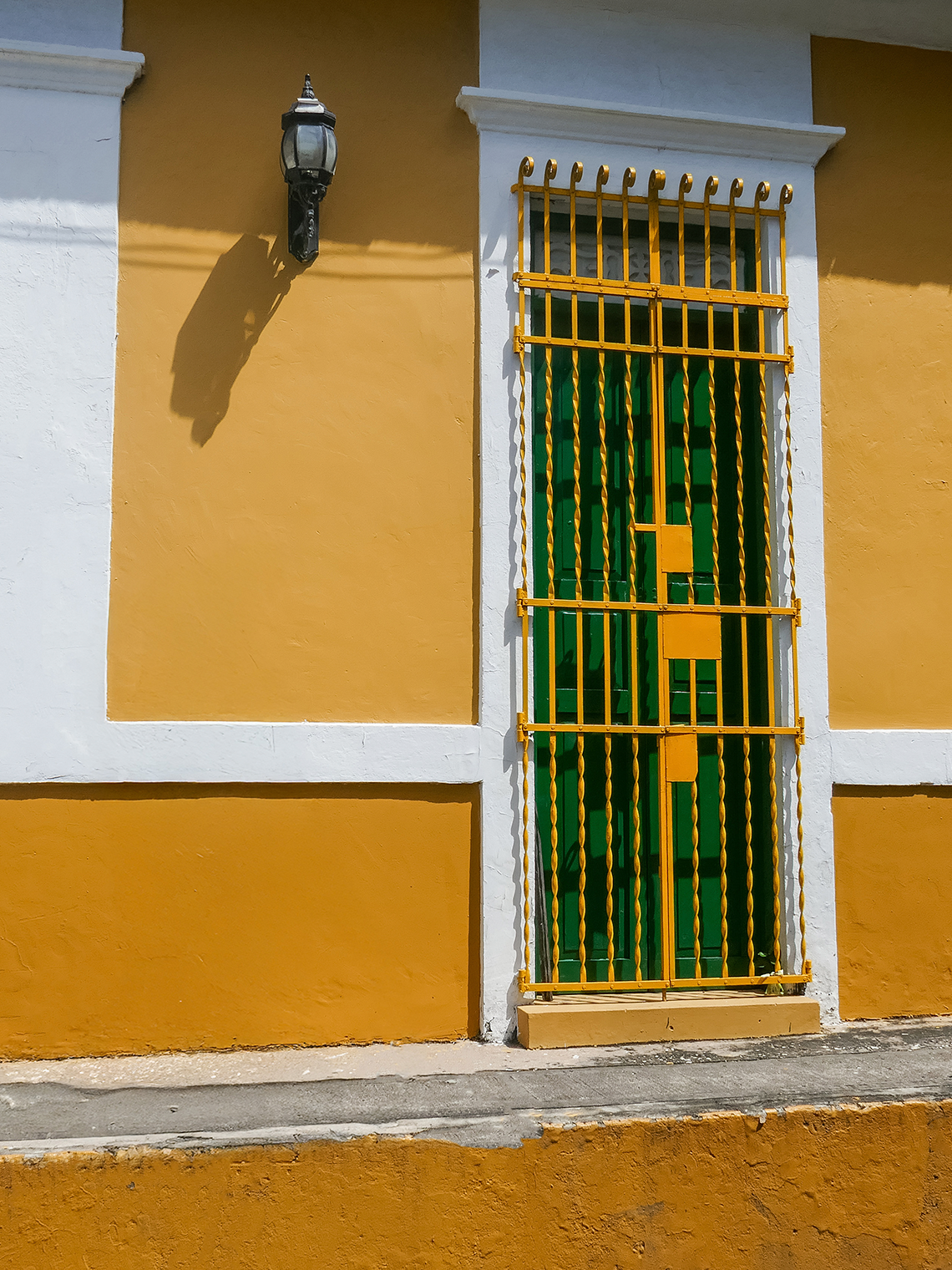 Puerta verde con rejas amarillas en Hotel Ribai Corporativa.