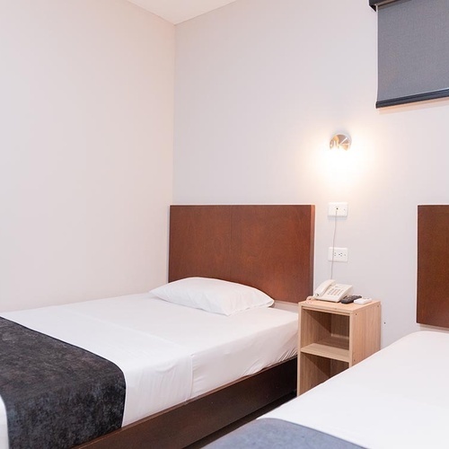 Habitación doble en Hotel Ribai Corporativa con camas individuales y decoración moderna.