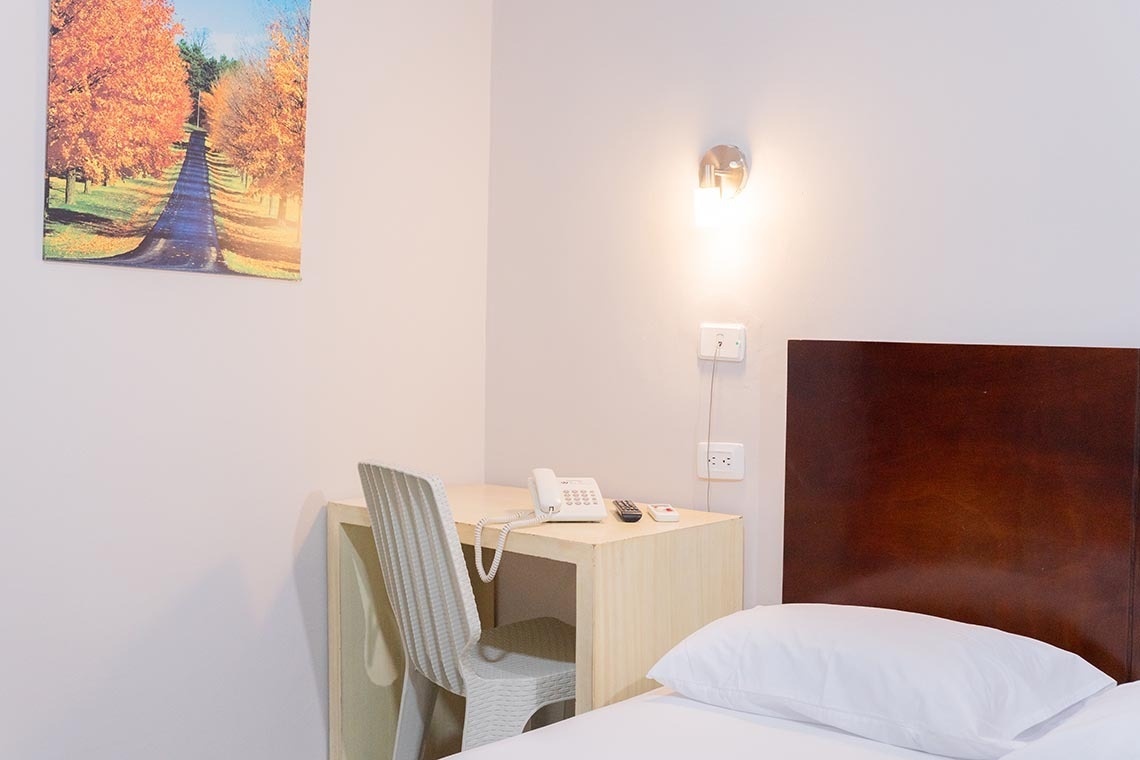 Escritorio con teléfono y silla blanca en Hotel Santa Marta | Ribai Hotels.