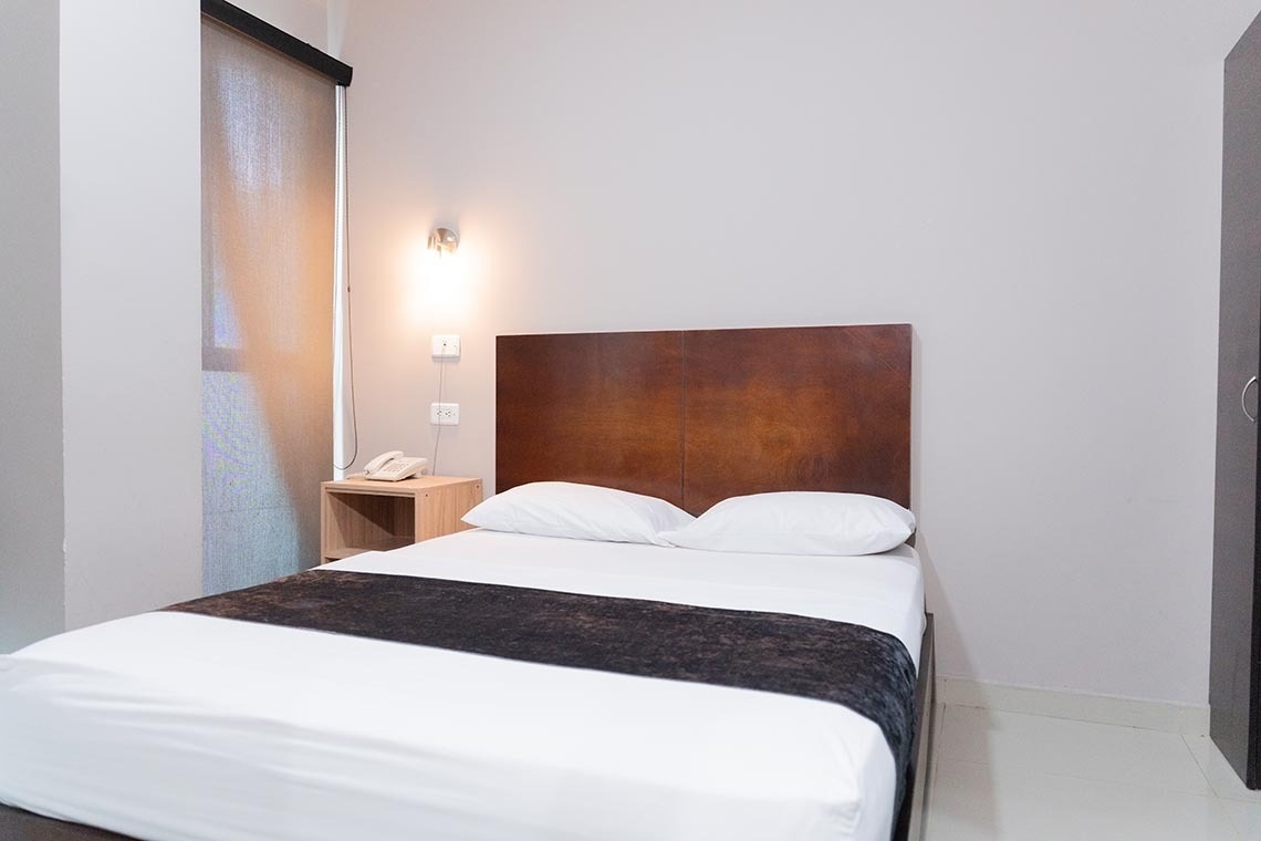 Habitación doble con cama cómoda y mesita de noche, Hotel Santa Marta | Ribai Hotels.