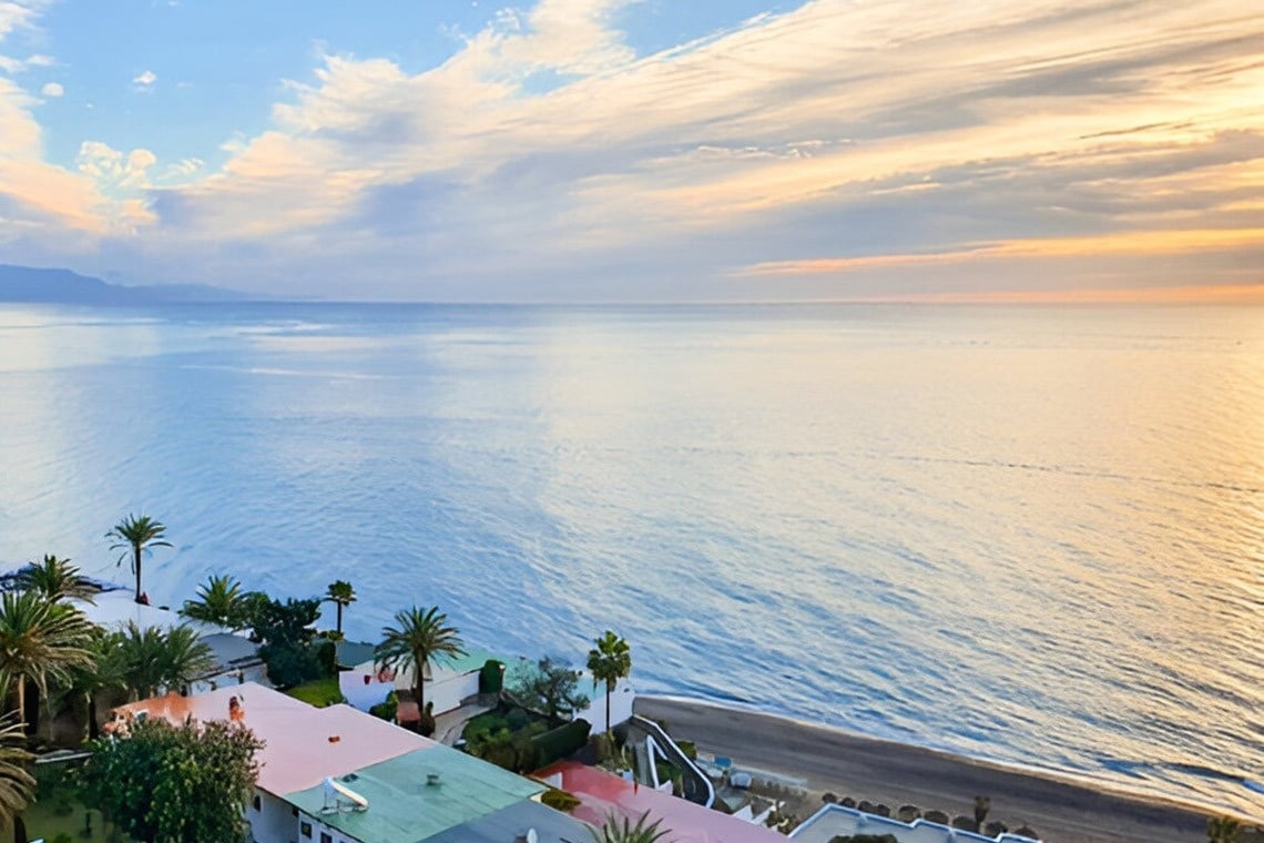 un edificio blanco con una vista del océano en el fondo