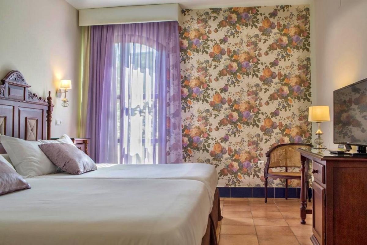 una habitación de hotel con dos camas y una televisión