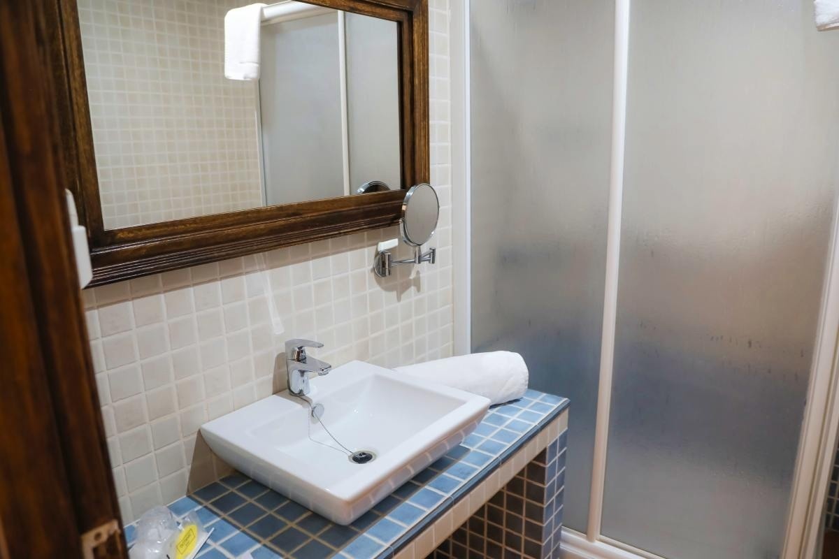 un baño con lavabo , espejo y ducha