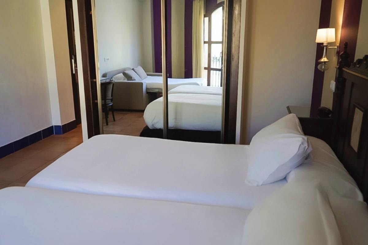 una habitación de hotel con dos camas y un sofá