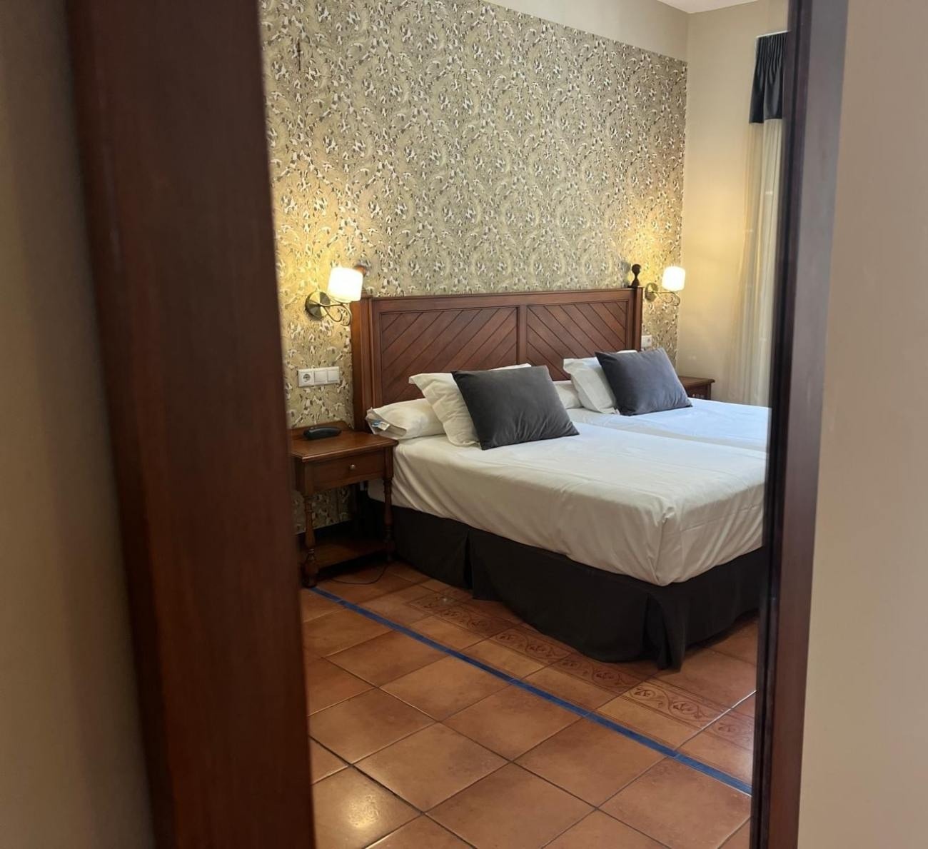 una habitación de hotel con dos camas y dos mesitas de noche