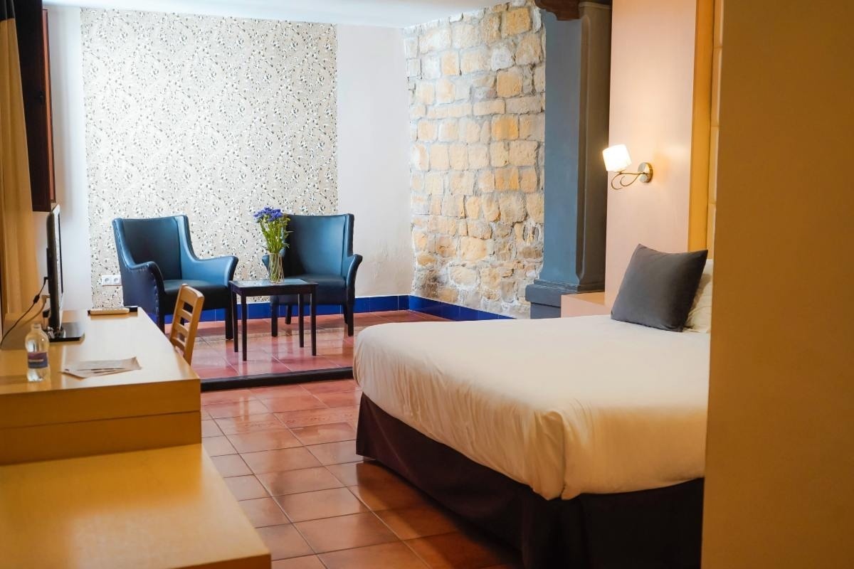 una habitación de hotel con una cama y dos sillas