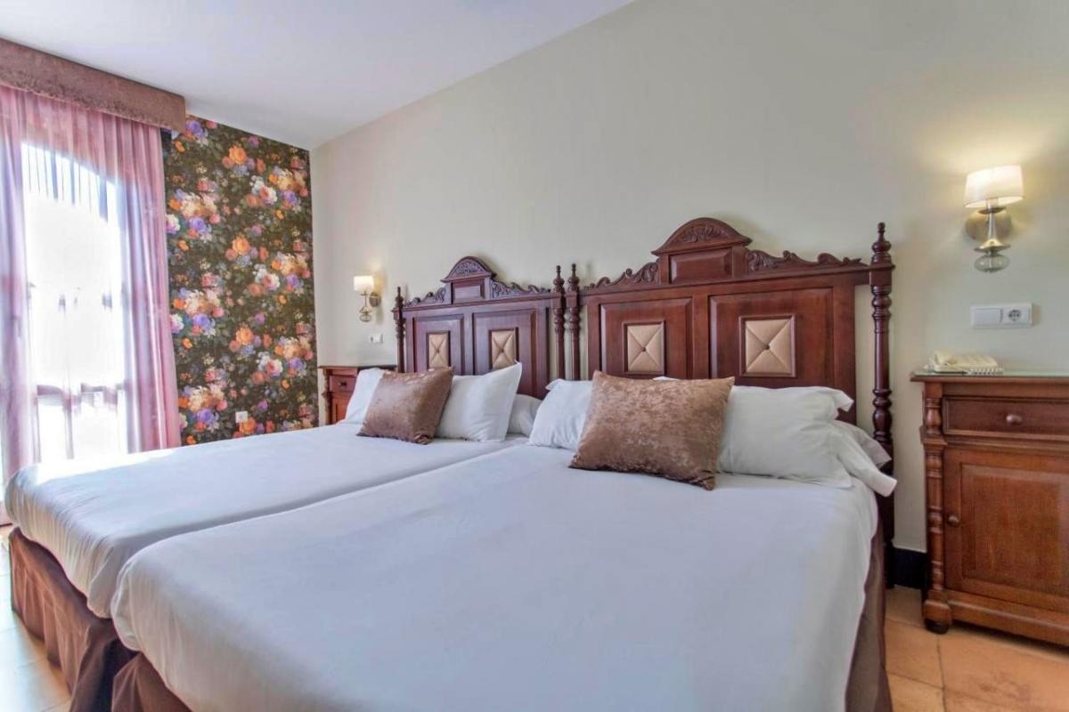 una habitación de hotel con dos camas y una ventana