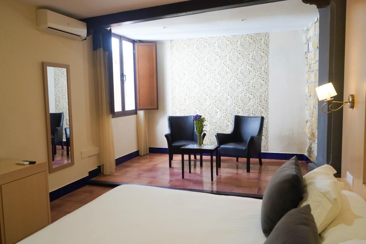 una habitación de hotel con una cama y dos sillas