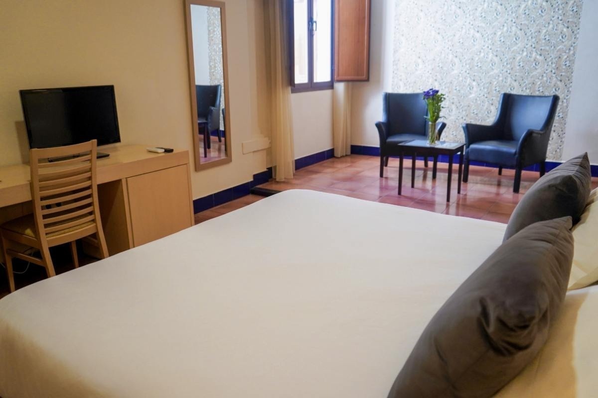 una habitación de hotel con una cama y dos sillas