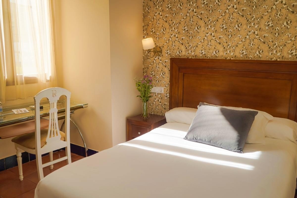 una habitación de hotel con dos camas y una ventana