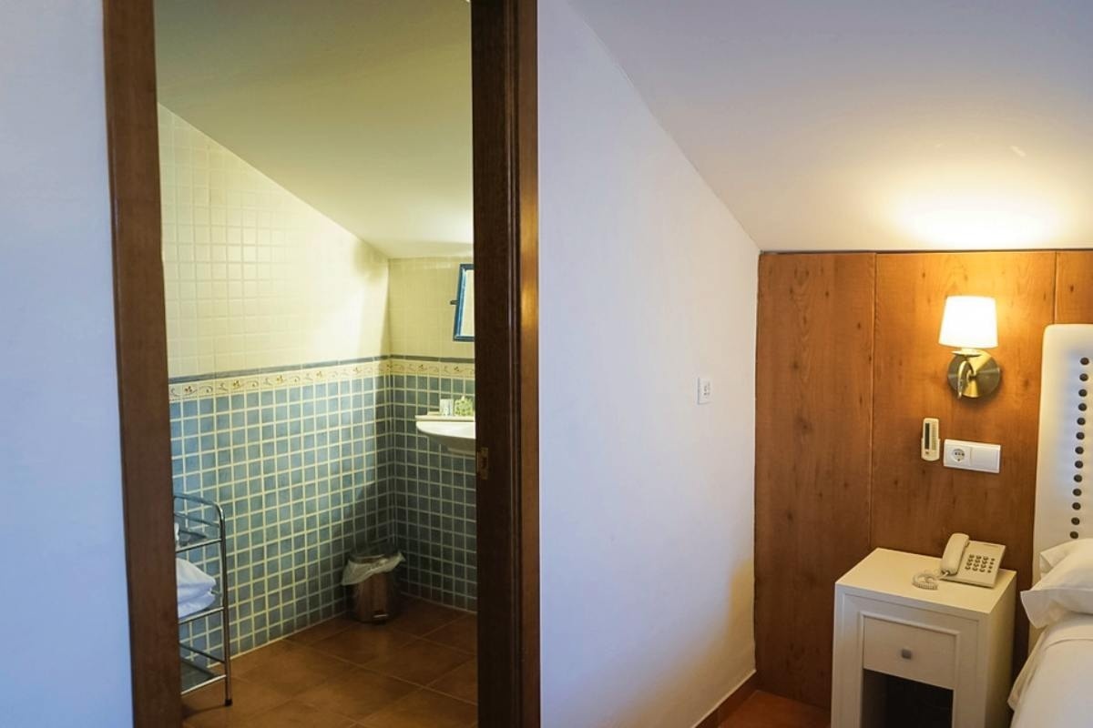 una puerta que conduce a un baño con azulejos azules y blancos