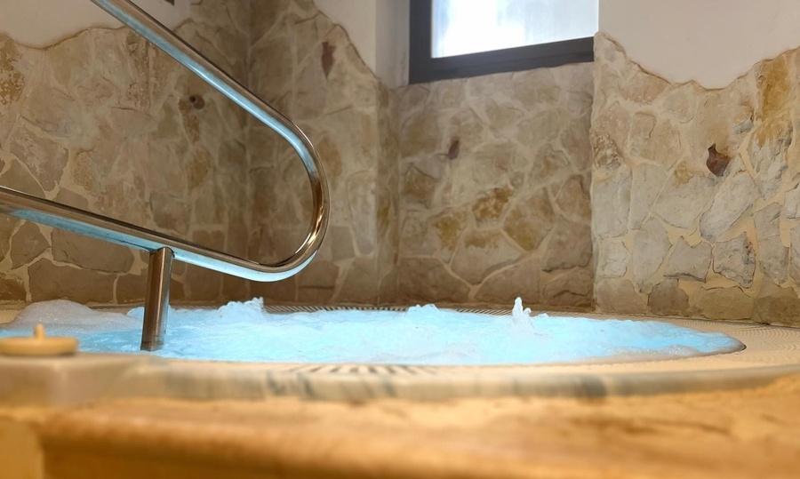 un jacuzzi rodeado de velas y pétalos de rosa