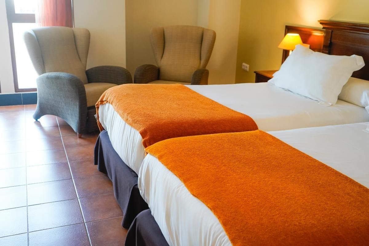 una habitación con dos camas y dos sillas