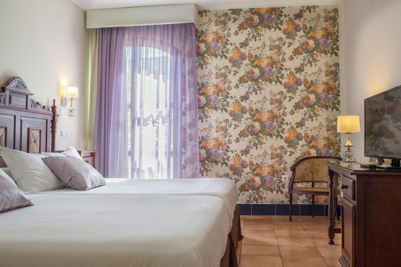 una habitación de hotel con dos camas y una ventana