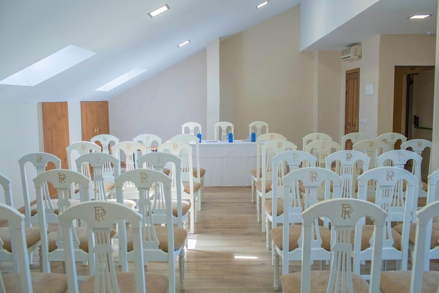 una fila de sillas blancas con la letra r en la parte posterior