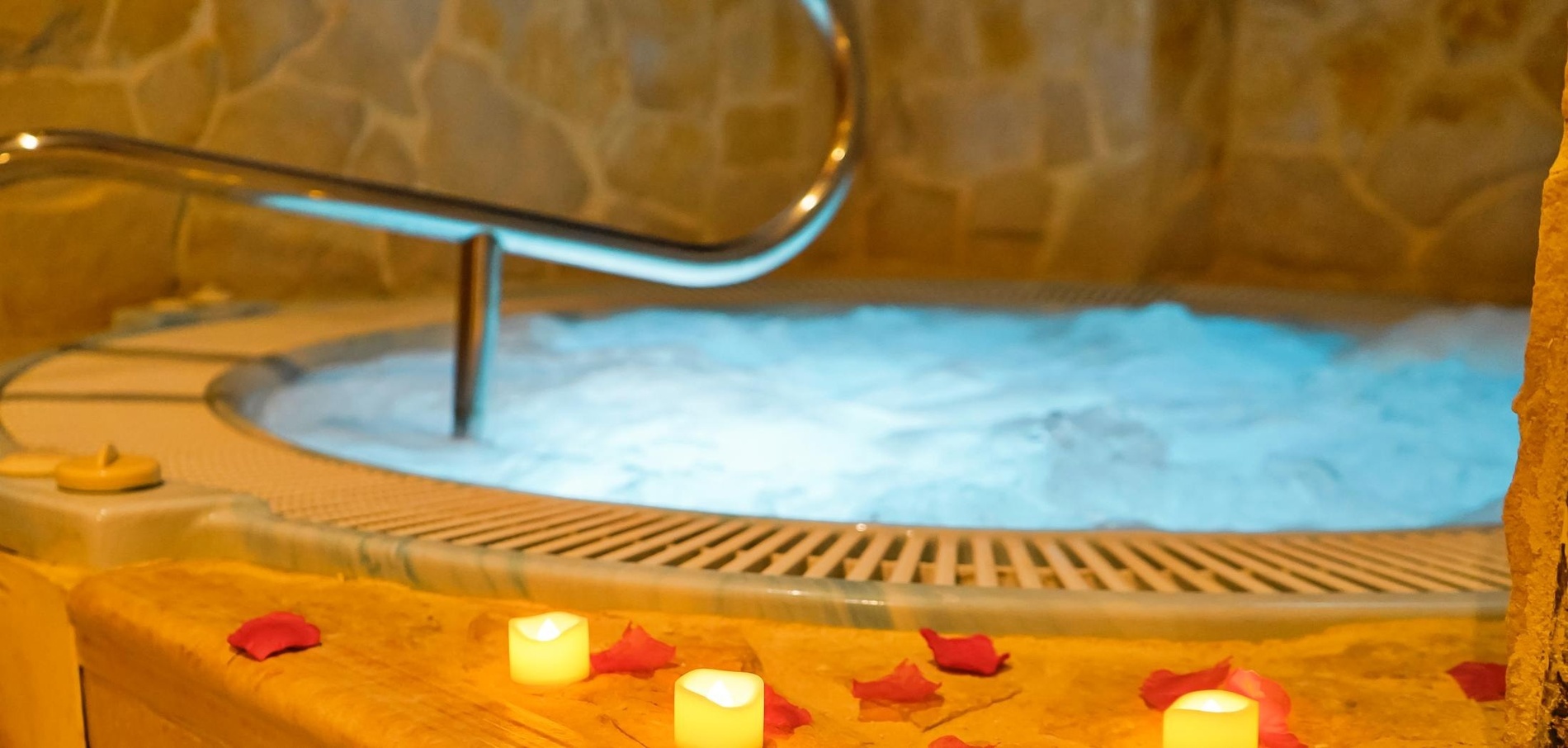 un jacuzzi rodeado de velas y pétalos de rosa