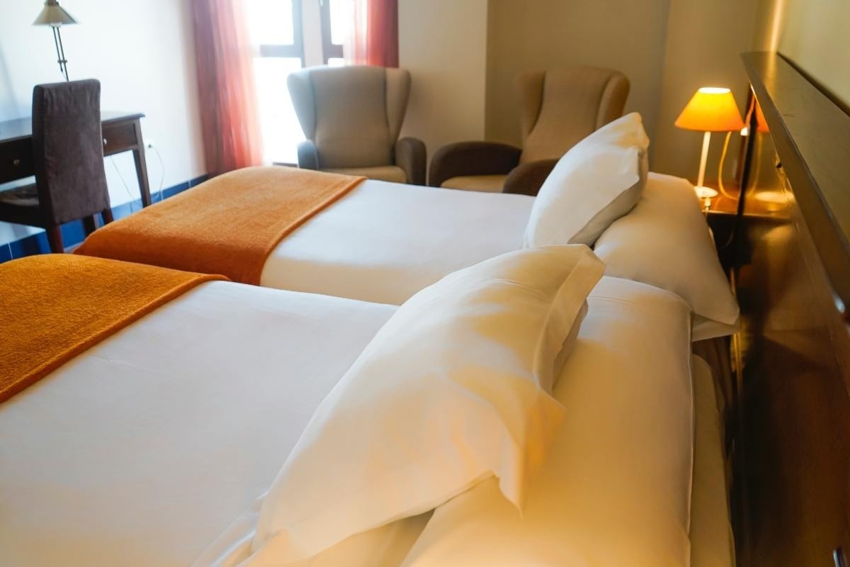 una habitación de hotel con dos camas y una ventana