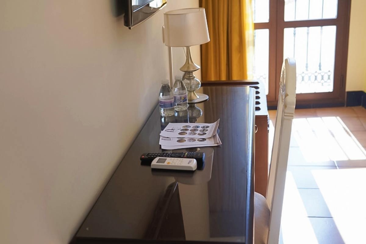 un escritorio con una botella de agua y un control remoto