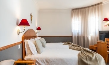 una habitación de hotel con dos camas , una mesa y una televisión .