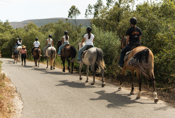 Couple horseback riding on a trail SA Hotels Serra D Aire at sunset.
