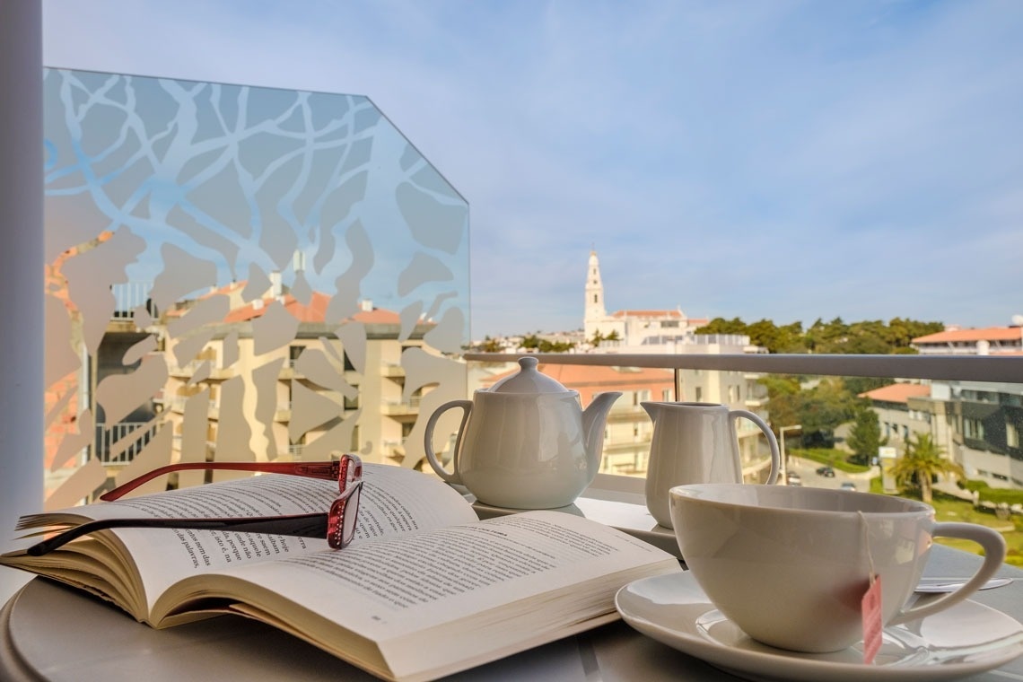 un libro abierto junto a una taza de té y una tetera