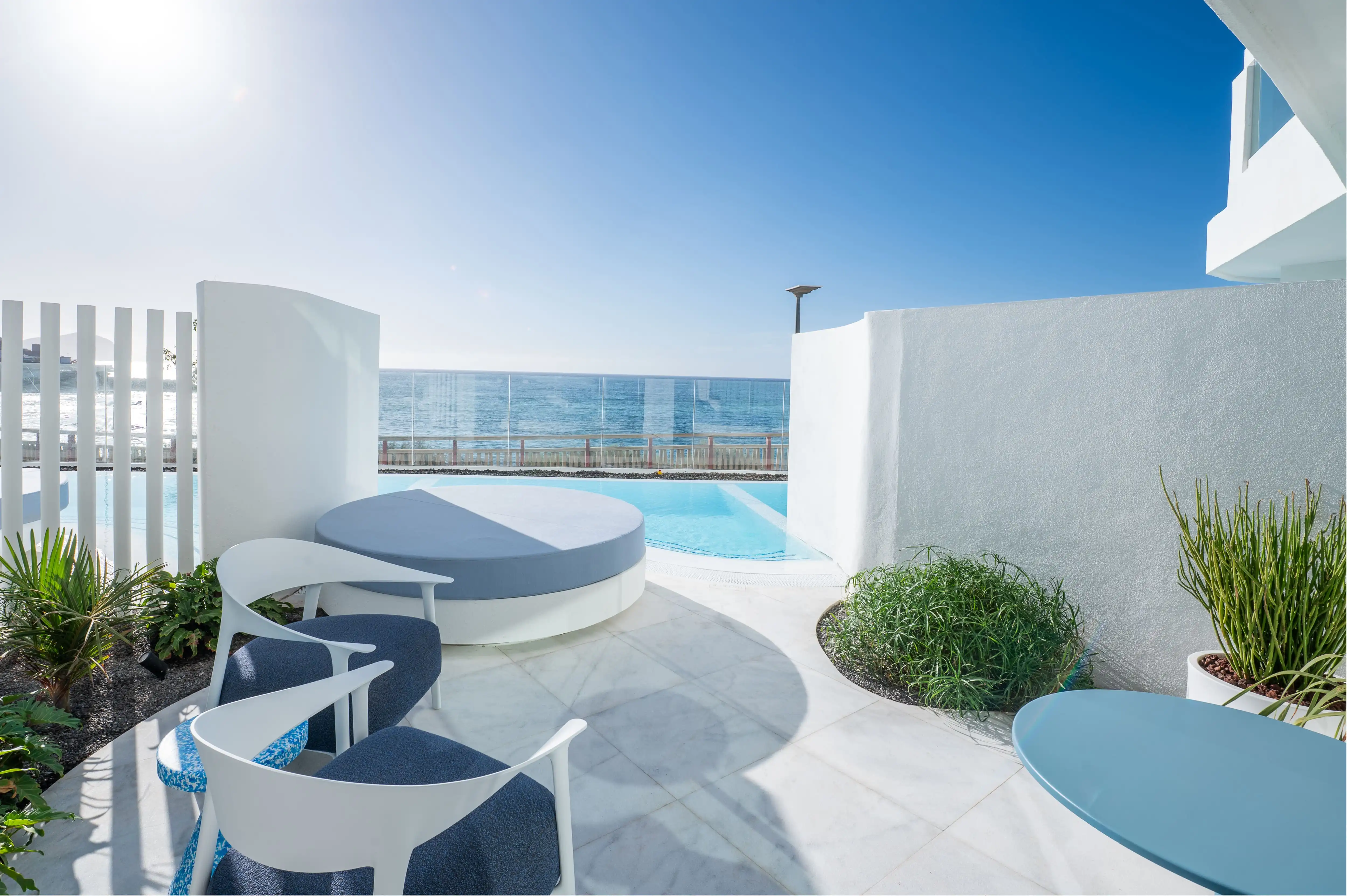 Terraza con piscina y vista al mar: The Salmar, mobiliario moderno y plantas.