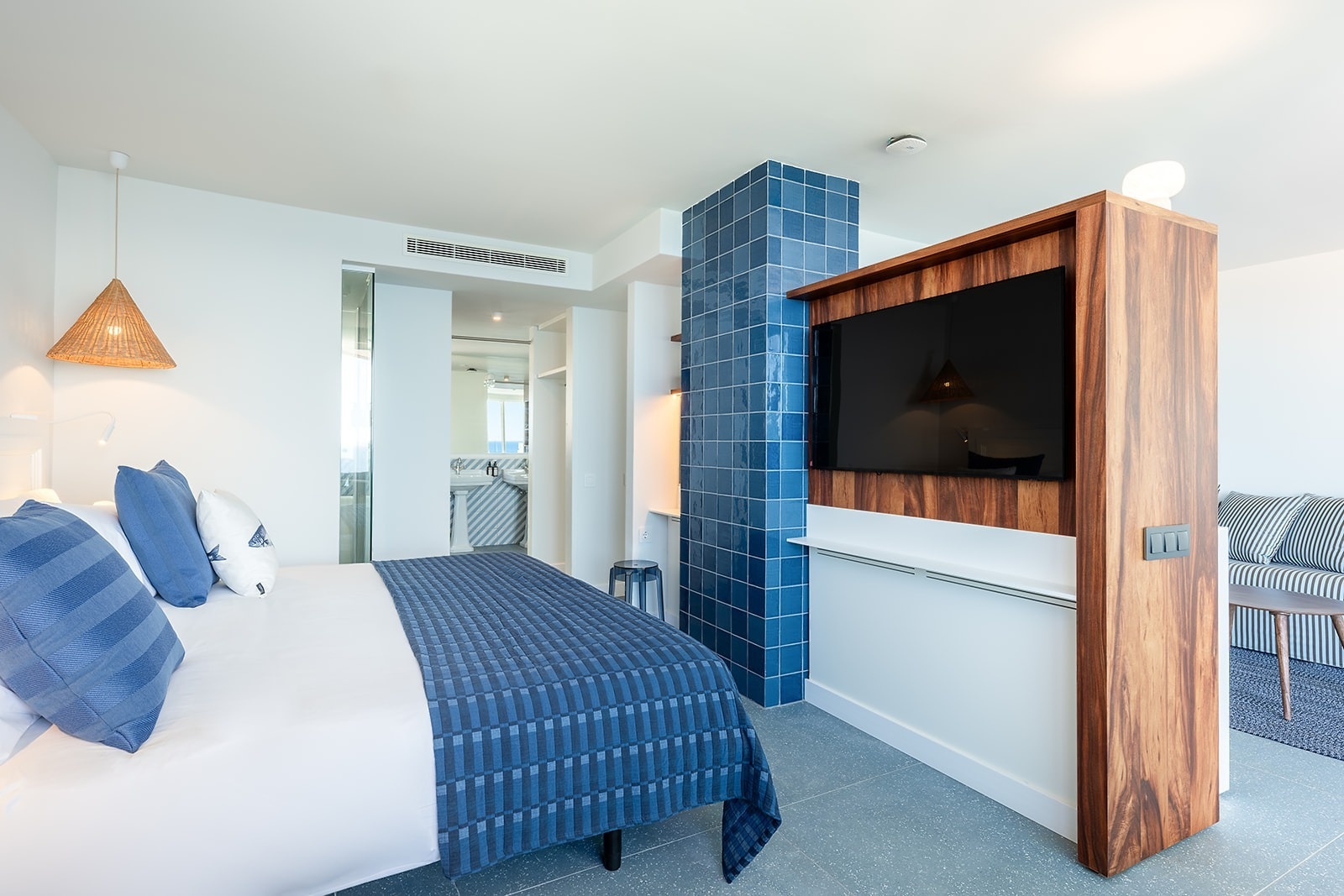 Satocan: The Salmar hotel room features a modern bedroom with a blue tiled accent wall and a mounted TV.