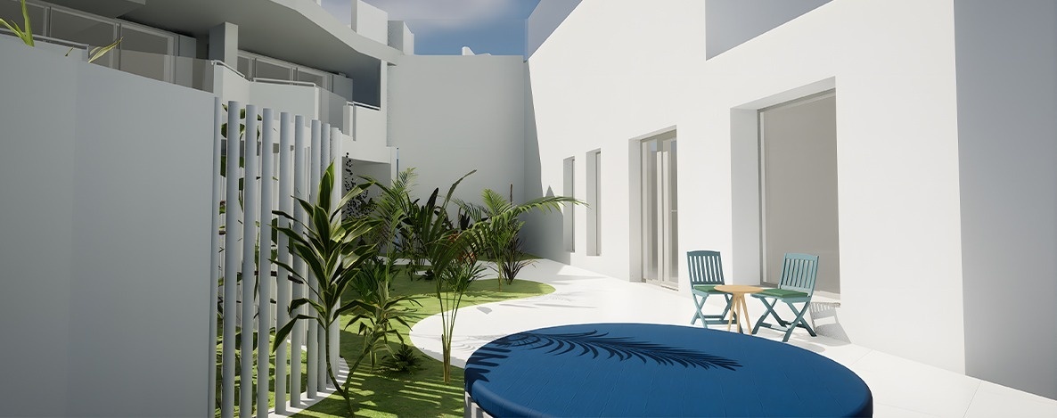A modern outdoor living space features minimalist white architecture, a lush green garden with various plants, and a patio area with a small table, two light blue chairs, and a large blue circular cover with a palm frond design.
