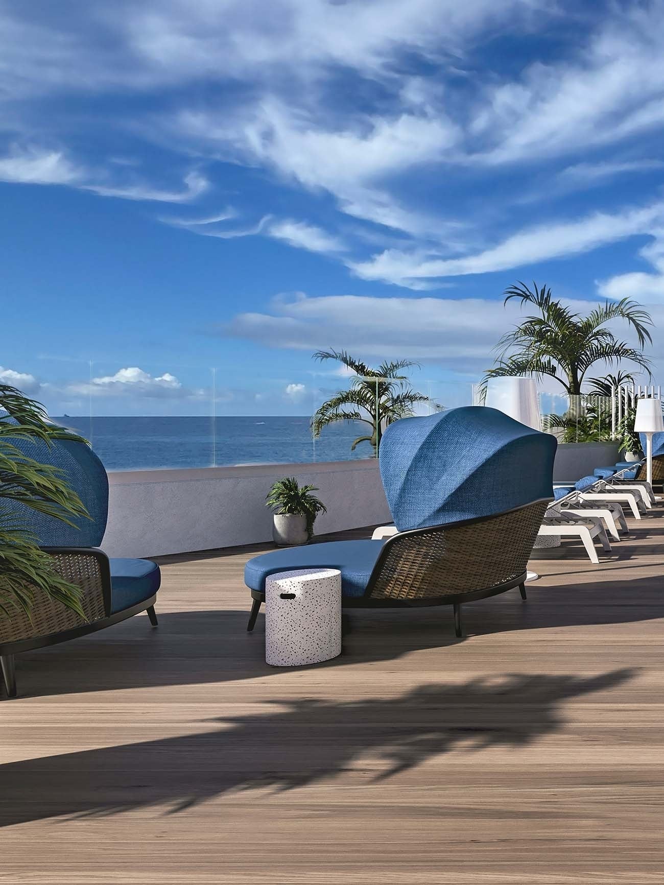Vistas panorámicas al océano Atlántico desde la terraza de The Salmar Tenerife con daybeds de mimbre con dosel azul y mobiliario de exterior de lujo.