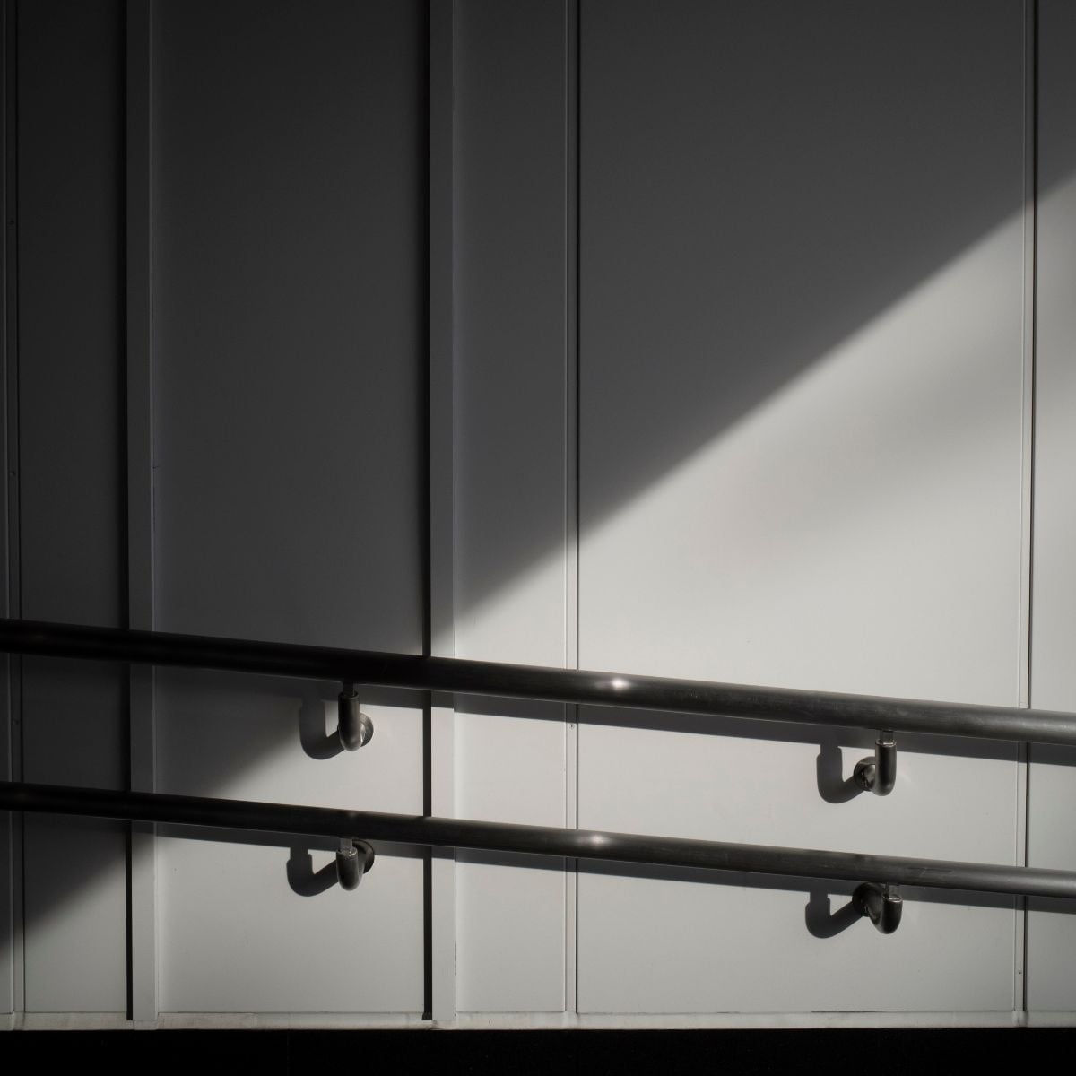 Una terraza moderna con una tumbona azul y una mesa auxiliar, ofrece una vista panorámica del vasto océano bajo un cielo despejado.