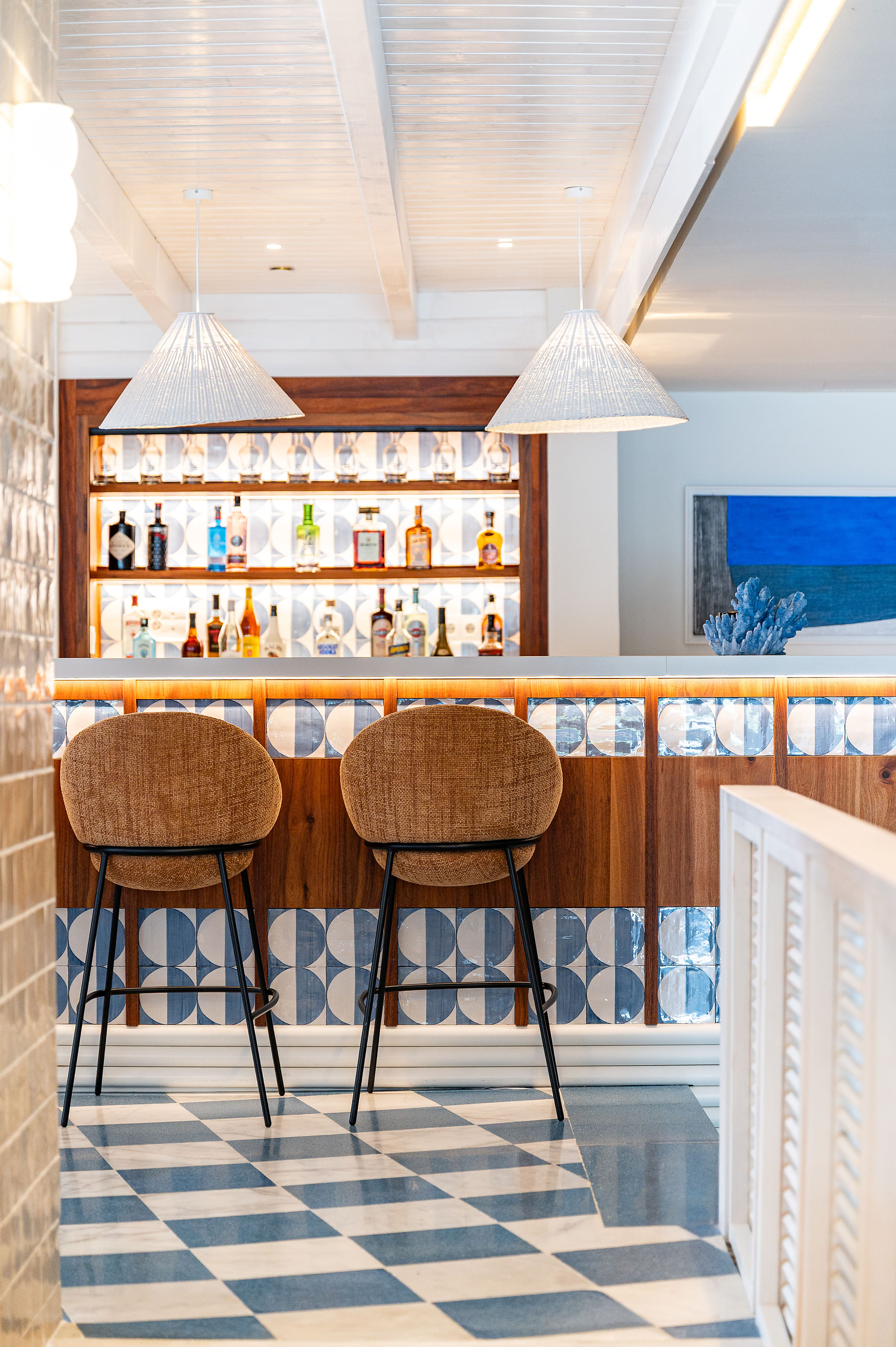 Bar moderno con taburetes y suelo a cuadros en The Salmar.