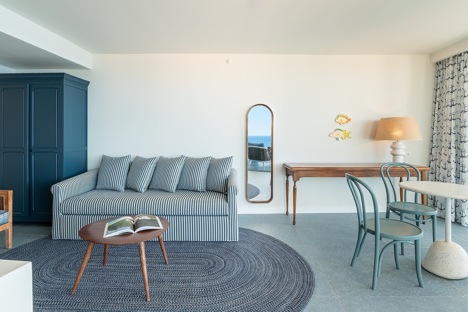 Satocan: The Salmar hotel room with striped sofa, blue cabinet, and seaside decor.