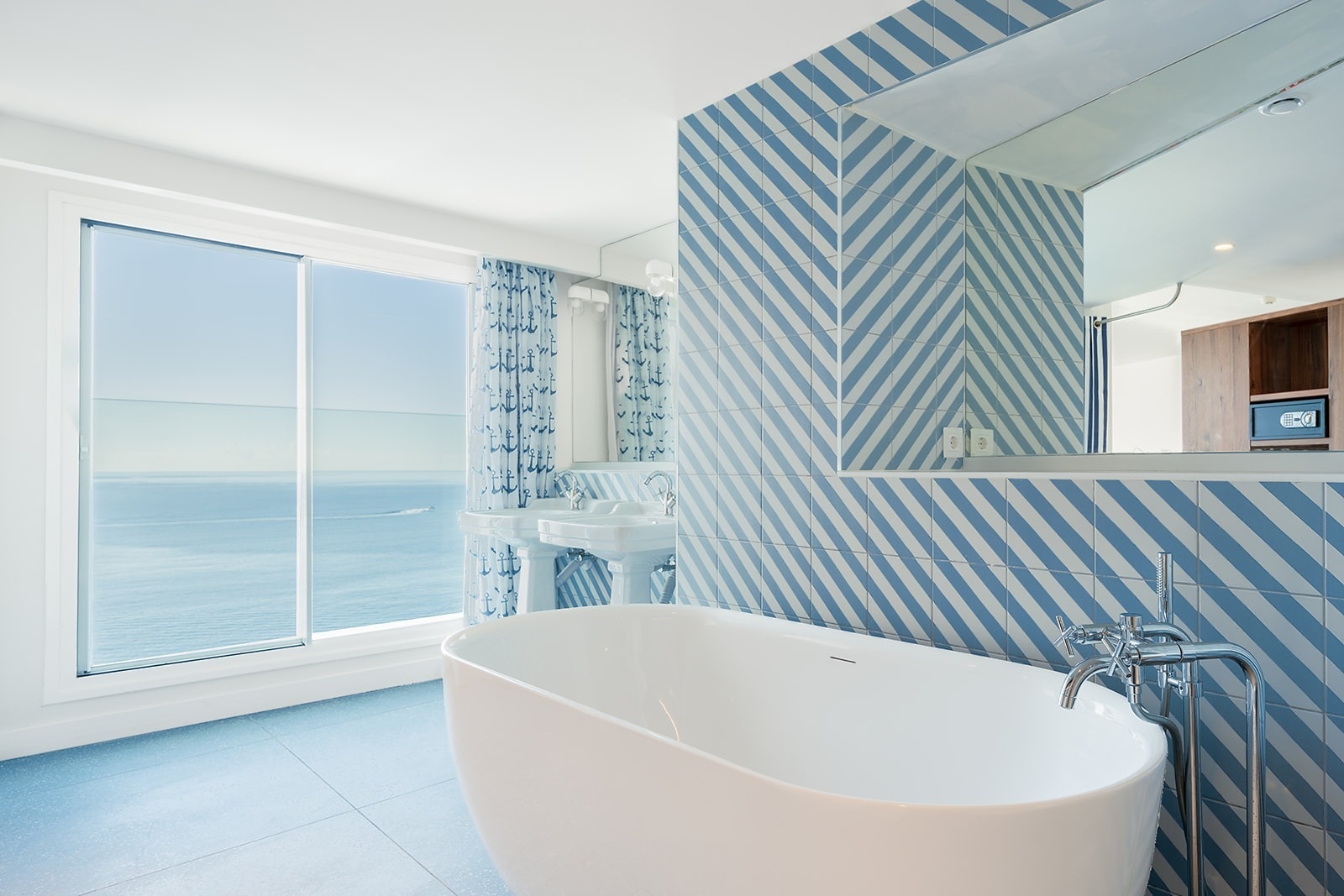 Satocan: The Salmar bathroom with ocean view, freestanding tub, and nautical tile.