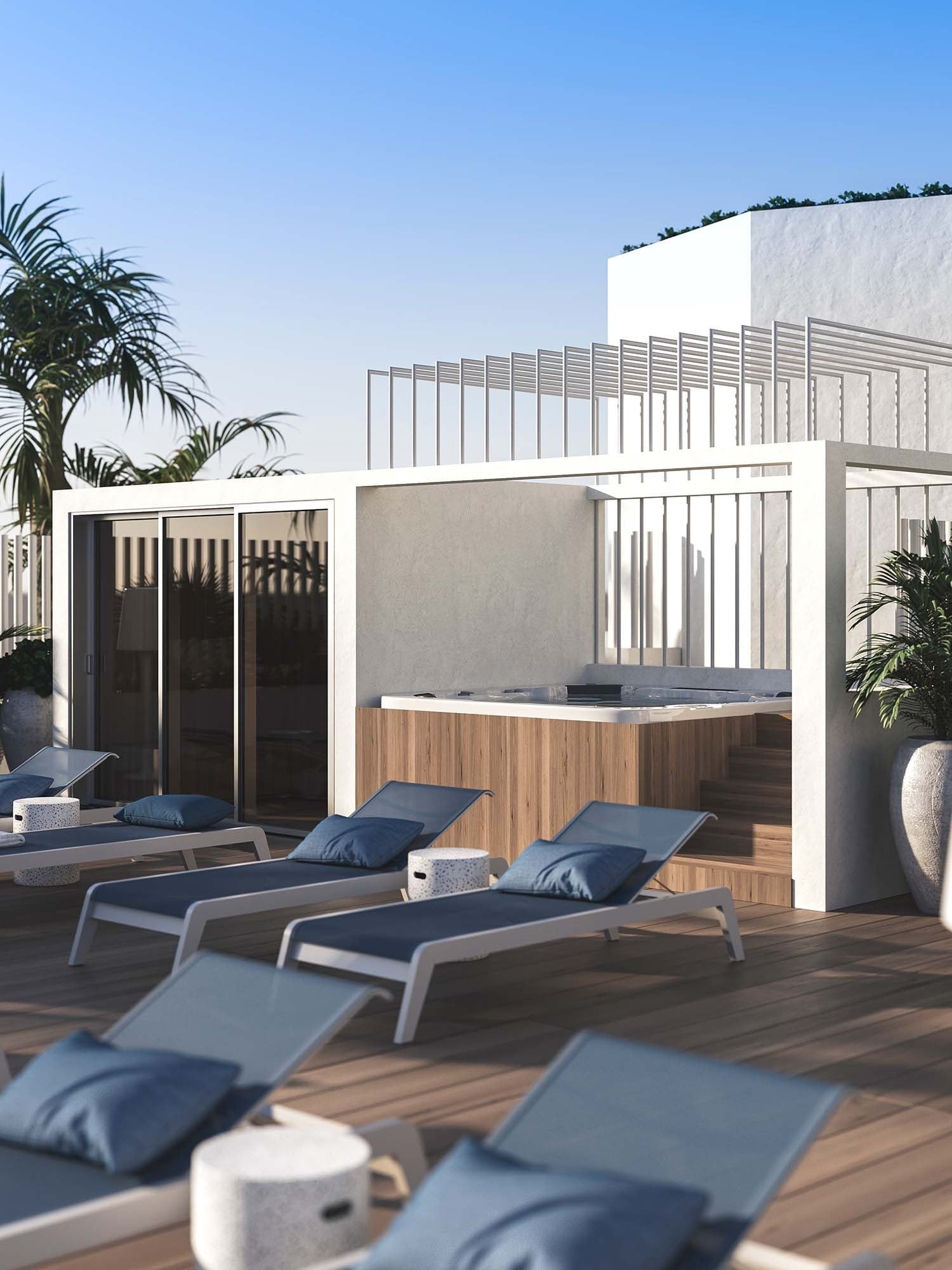 Zona de solarium en The Salmar Tenerife con tumbonas azules, suelo de madera y jacuzzi exterior de diseño integrado en una estructura minimalista blanca.