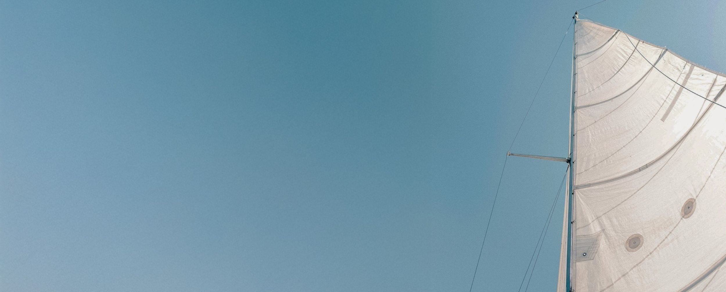 Una mujer, vista de espaldas, se encuentra en una piscina infinita mirando hacia el océano.