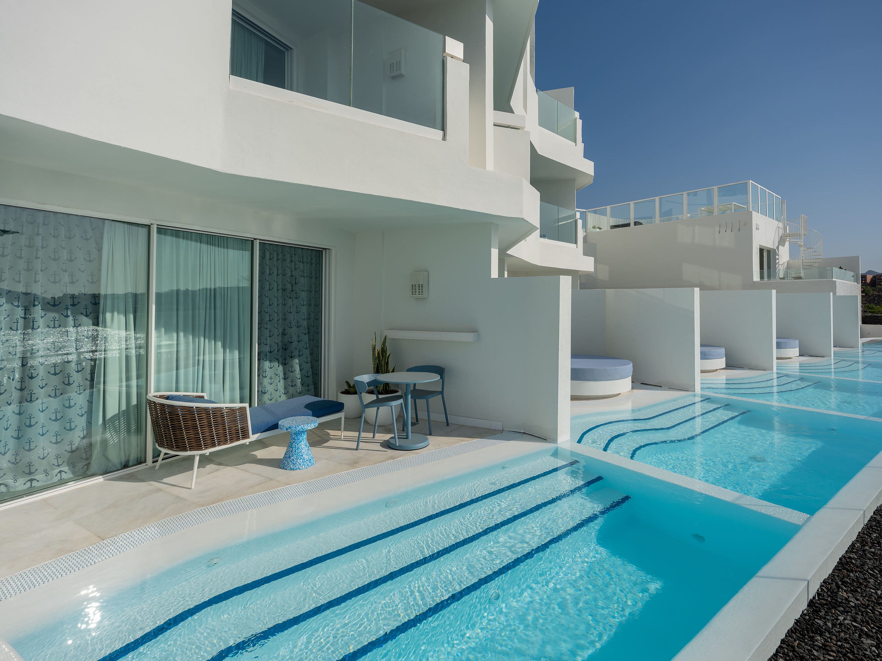 Satocan: The Salmar - Piscina y patio con muebles modernos y vegetación exuberante.