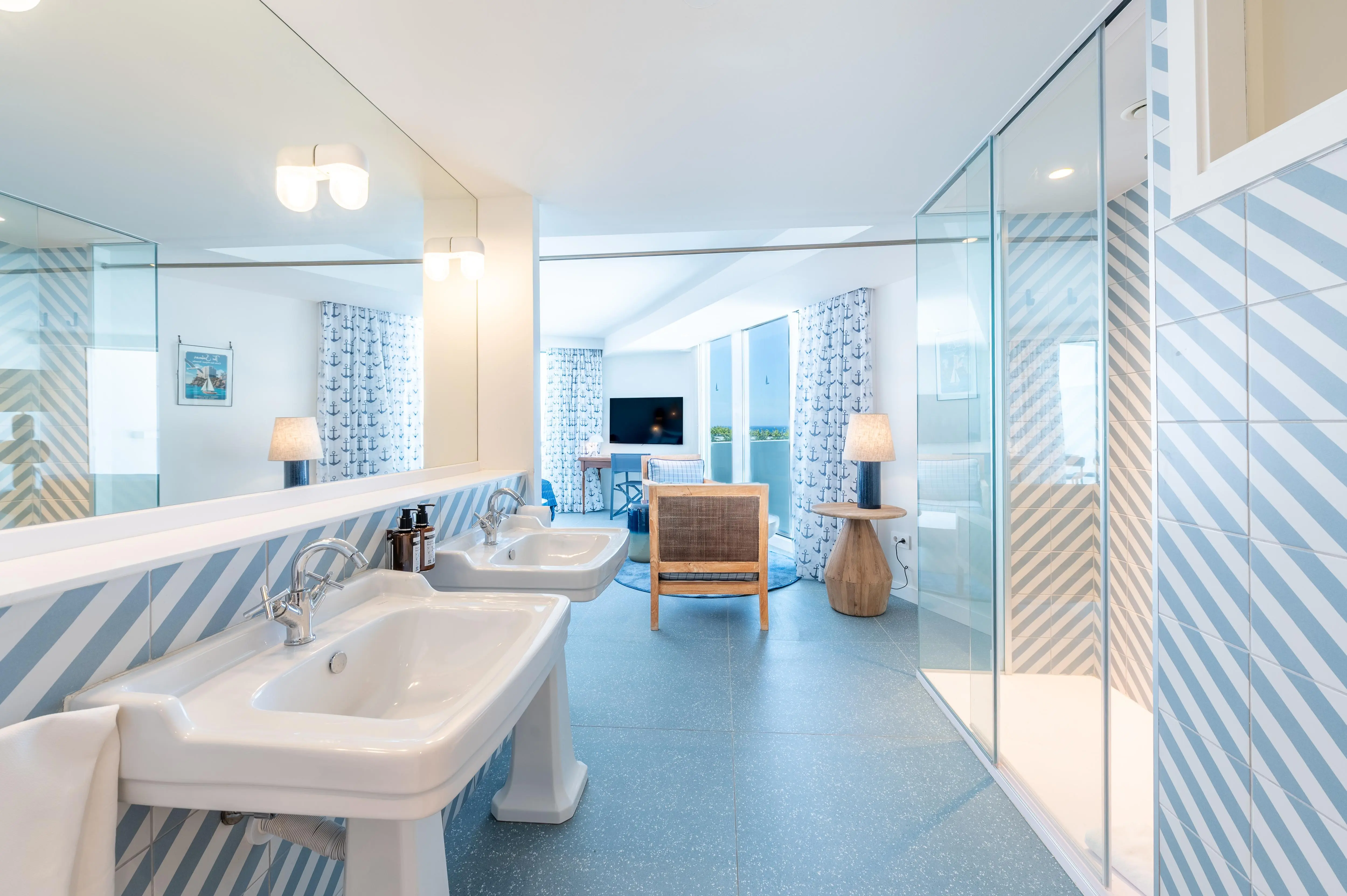 Baño en suite elegante con doble lavabo y acabados modernos en hotel The Salmar