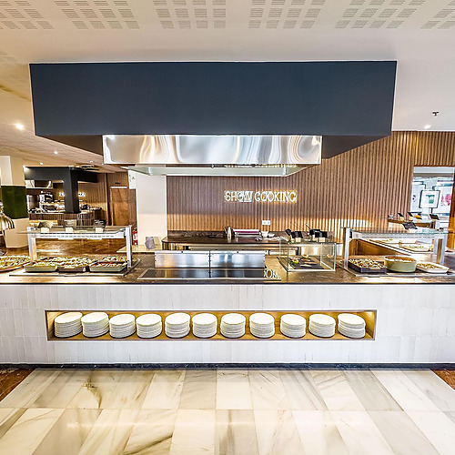 Buffet de comida 'Dorobe: Hotel San Fermin' en hotel con estación de cocina en vivo.
