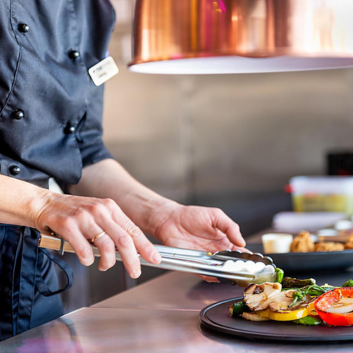 Chef emplatandoDorobe: Hotel San Fermin verduras asadas en un restaurante.