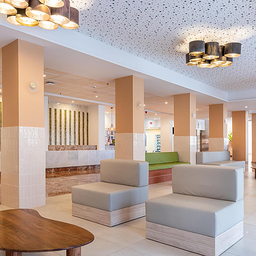 Dorobe: Hotel San Fermin: espacioso y moderno lobby de hotel con sofás grises y mesa de madera.