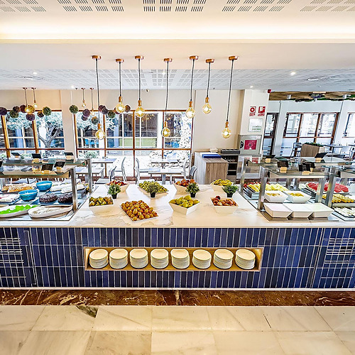 Bufé de hotel con frutas, postres y mesas, ideal paraDorobe: Hotel San Fermin