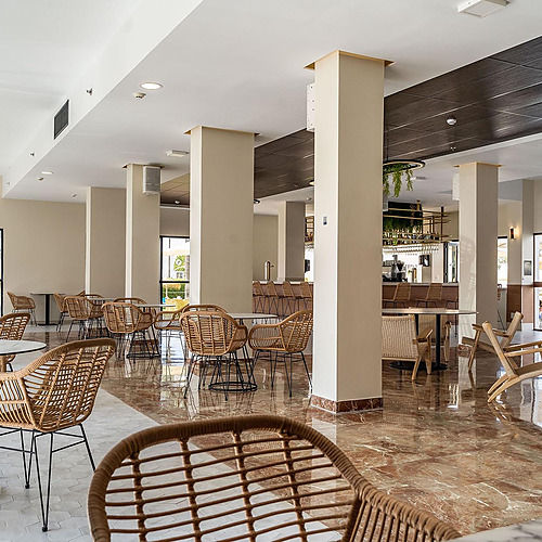 Comedor con sillas de ratán y mesas redondas, ideal para tu Dorobe: Hotel San Fermin.