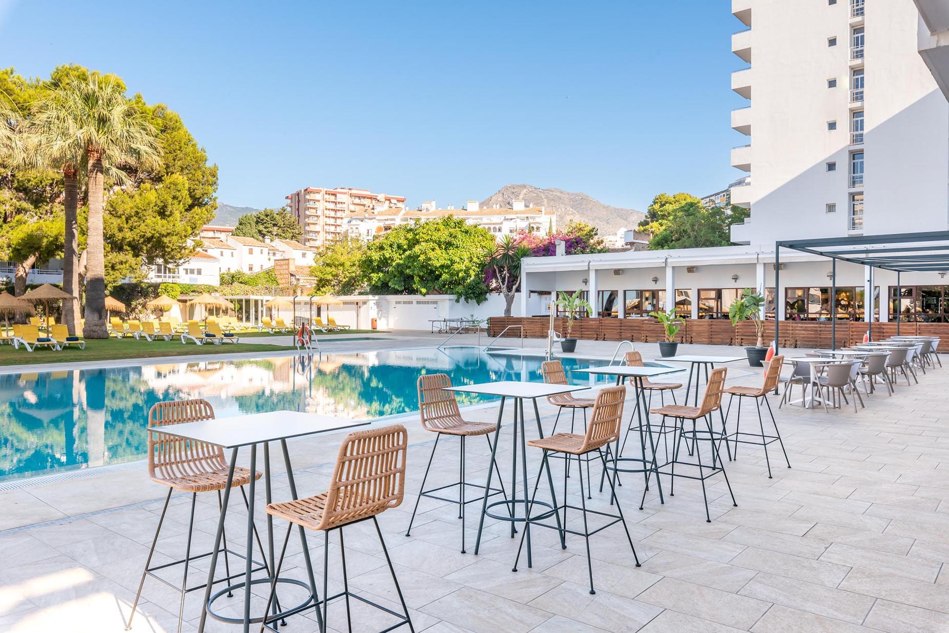 Entrada de hotel con luces, plantas y logo "Servicios | Hotel Parasol by Dorobe | Torremolinos".