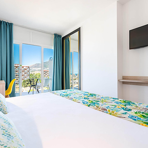 Cama cómoda en habitación de hotel con balcón y vista al mar. Dorobe: Hotel San Fermin