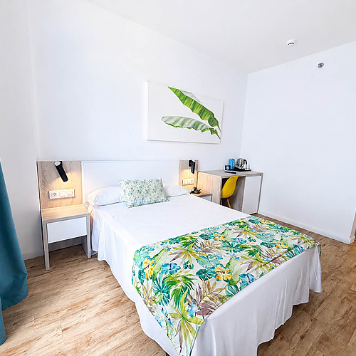 Cama cómoda en habitación de hotel conDorobe: Hotel San Fermin, escritorio y cortinas.