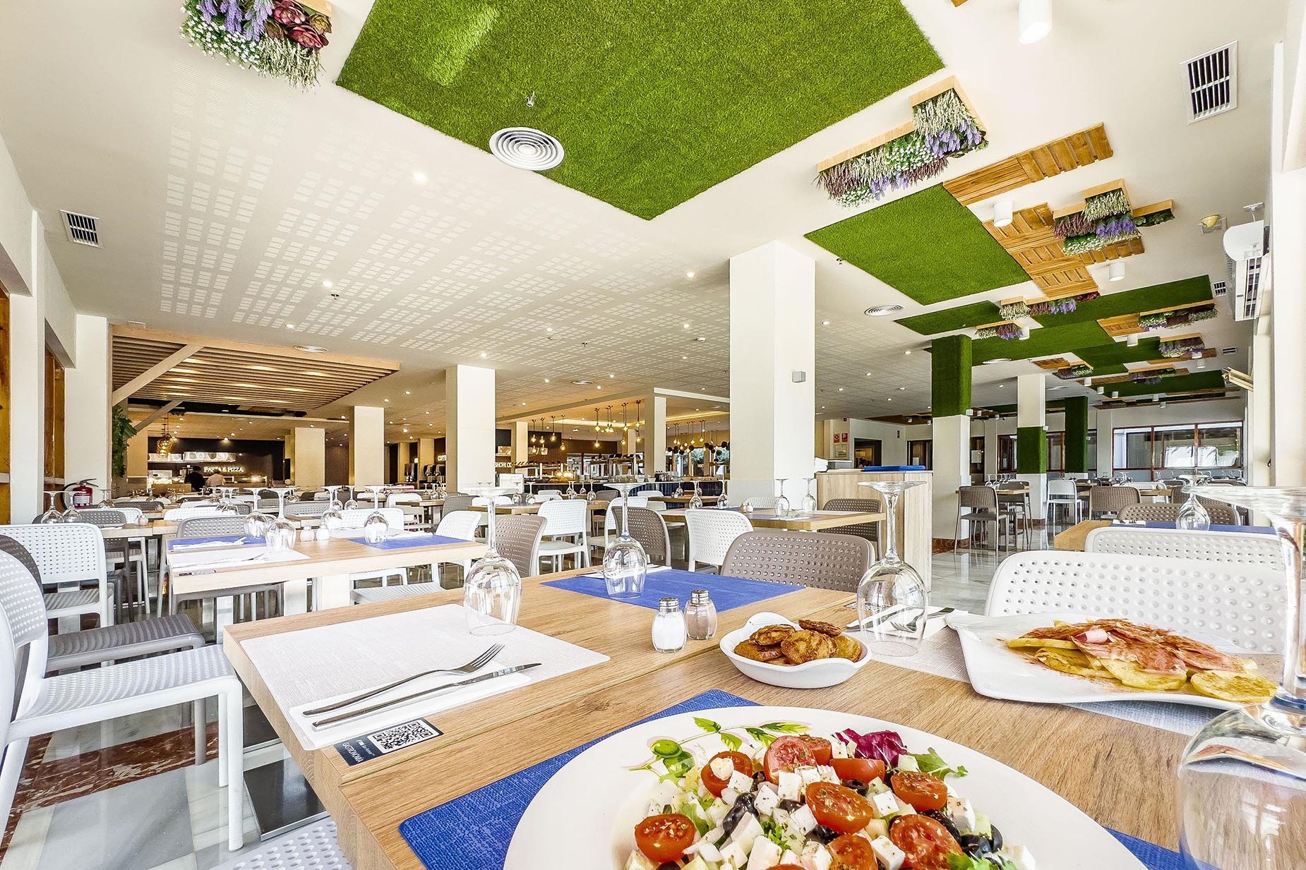 Restaurante buffet moderno en Dorobe: Hotel San Fermín, con césped artificial en el techo.